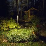 an outdoor area at night with a tall garden light.