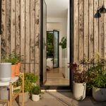 A wireless Sonos speaker in an outdoor space, surrounded by plants.