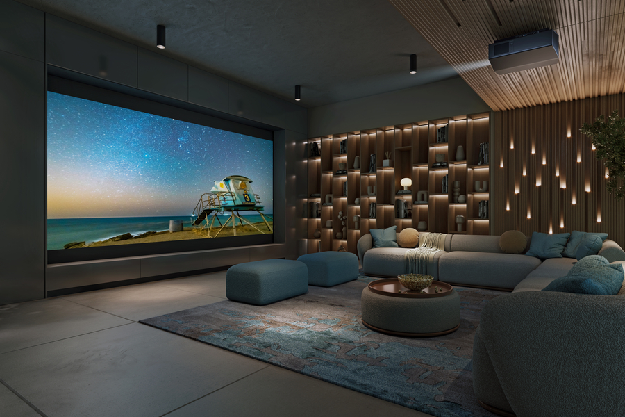 A modern home theater with a large projection screen displaying a scenic beach and starry sky, surrounded by acoustic treatments, and a cozy seating area.